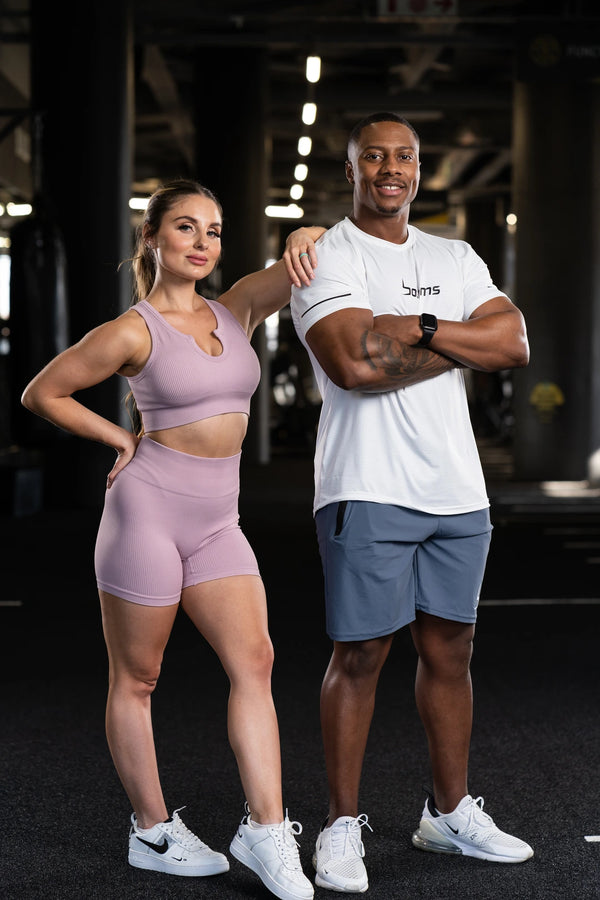 man wearing botthms white sport t-shirt standing beside a woman in workout dressup