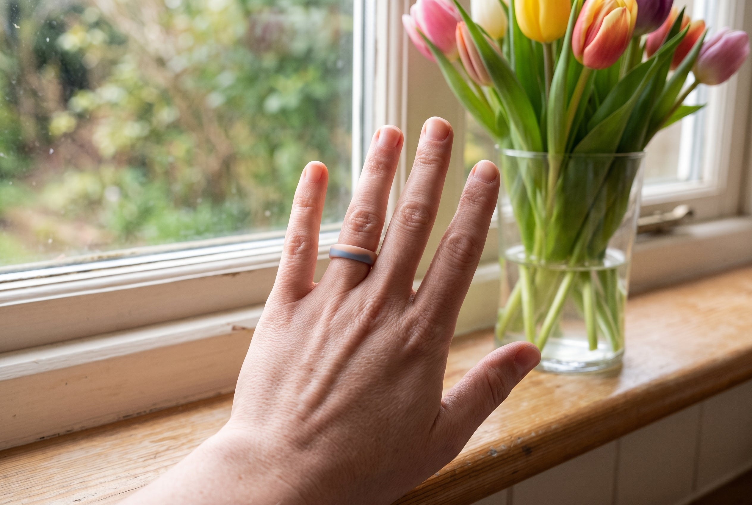 Peach and blue flow women's silicone ring worn by a kitchen windowsill beside a vase of tulips