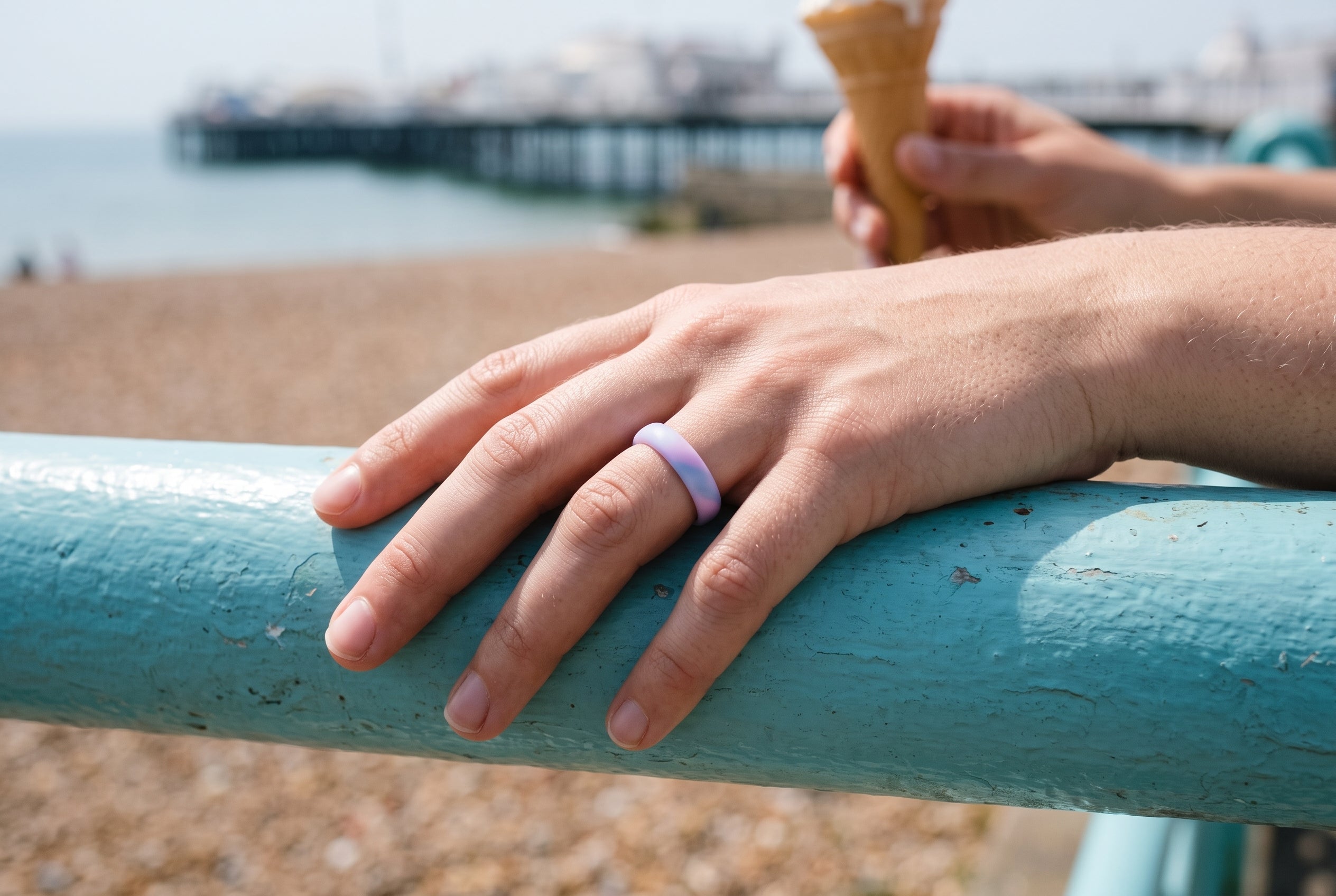 Aqua pink swirl women's silicone ring worn on the seafront railing in Brighton