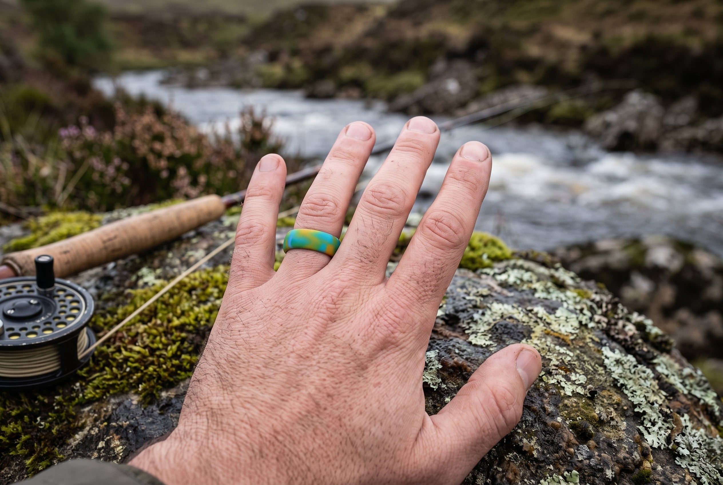 Green yellow flow men's silicone ring worn by an angler on a Scottish Highland riverbank