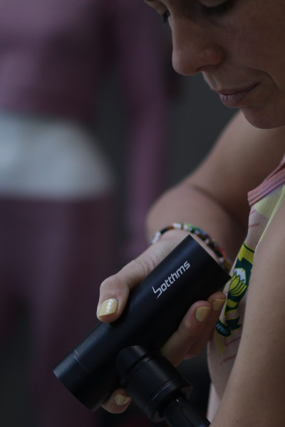 person trying botthms massage gun on left hand