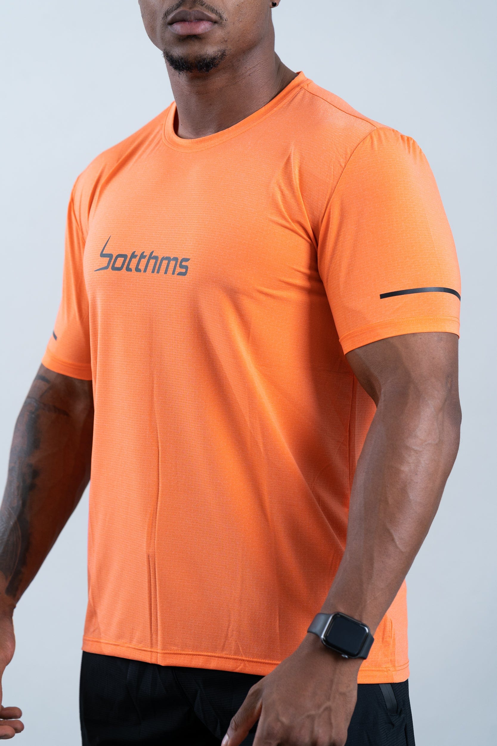 athlete wearing botthms orange sport t-shirt - front left closeup view