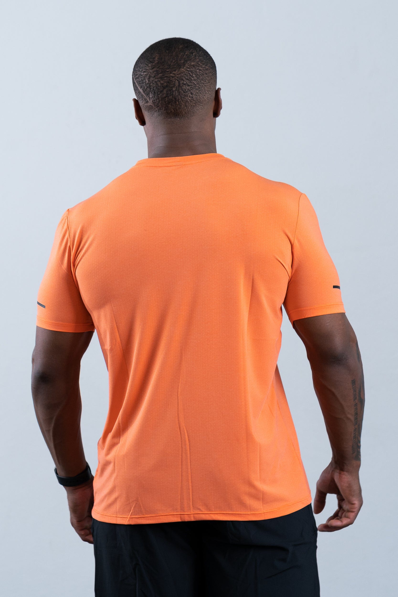 athlete wearing botthms orange sport t-shirt - rear view