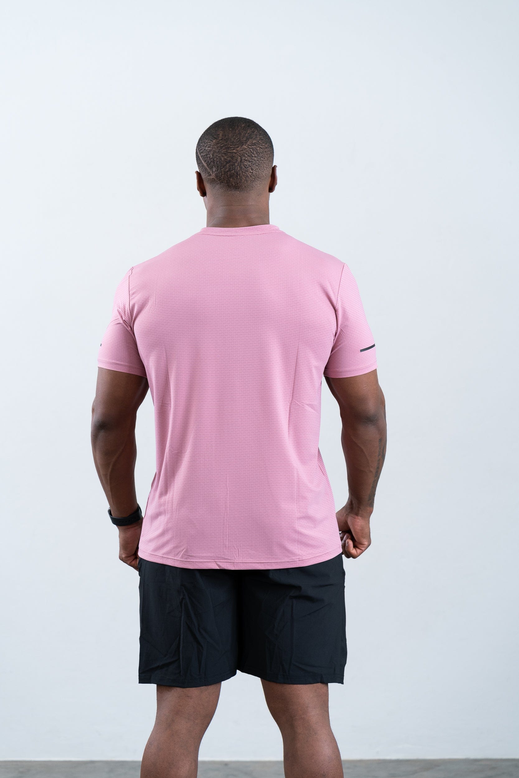athlete wearing botthms pink sport t-shirt- rear view