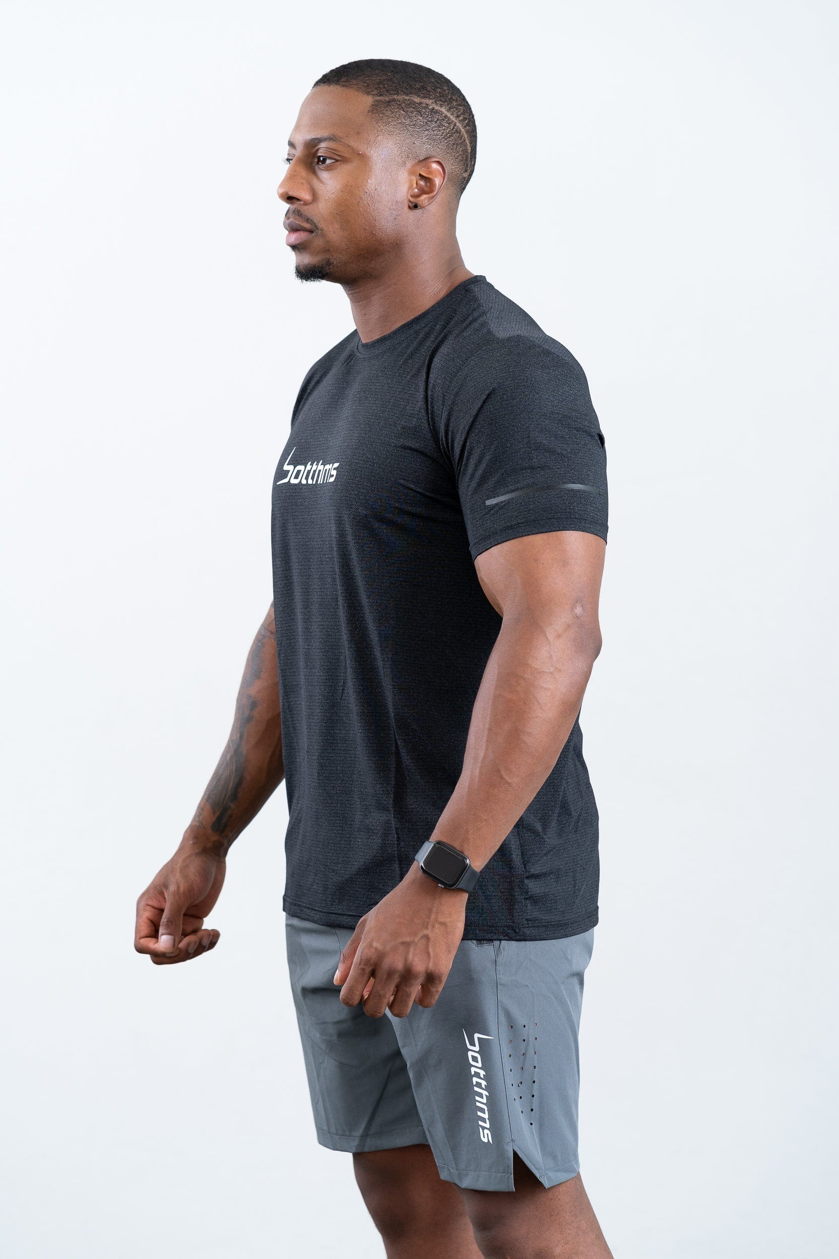 man standing wearing botthms black sport t-shirt- left view