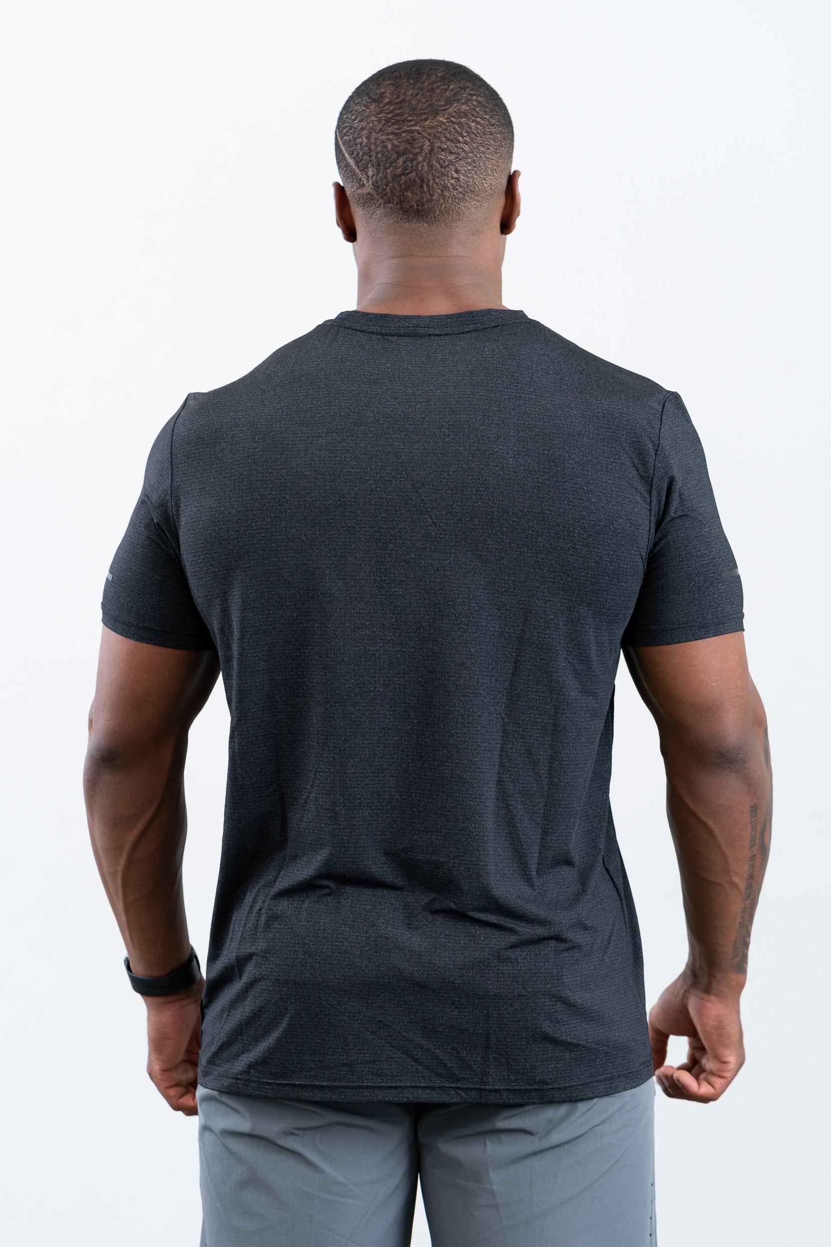 man standing wearing botthms black sport t-shirt - rear view
