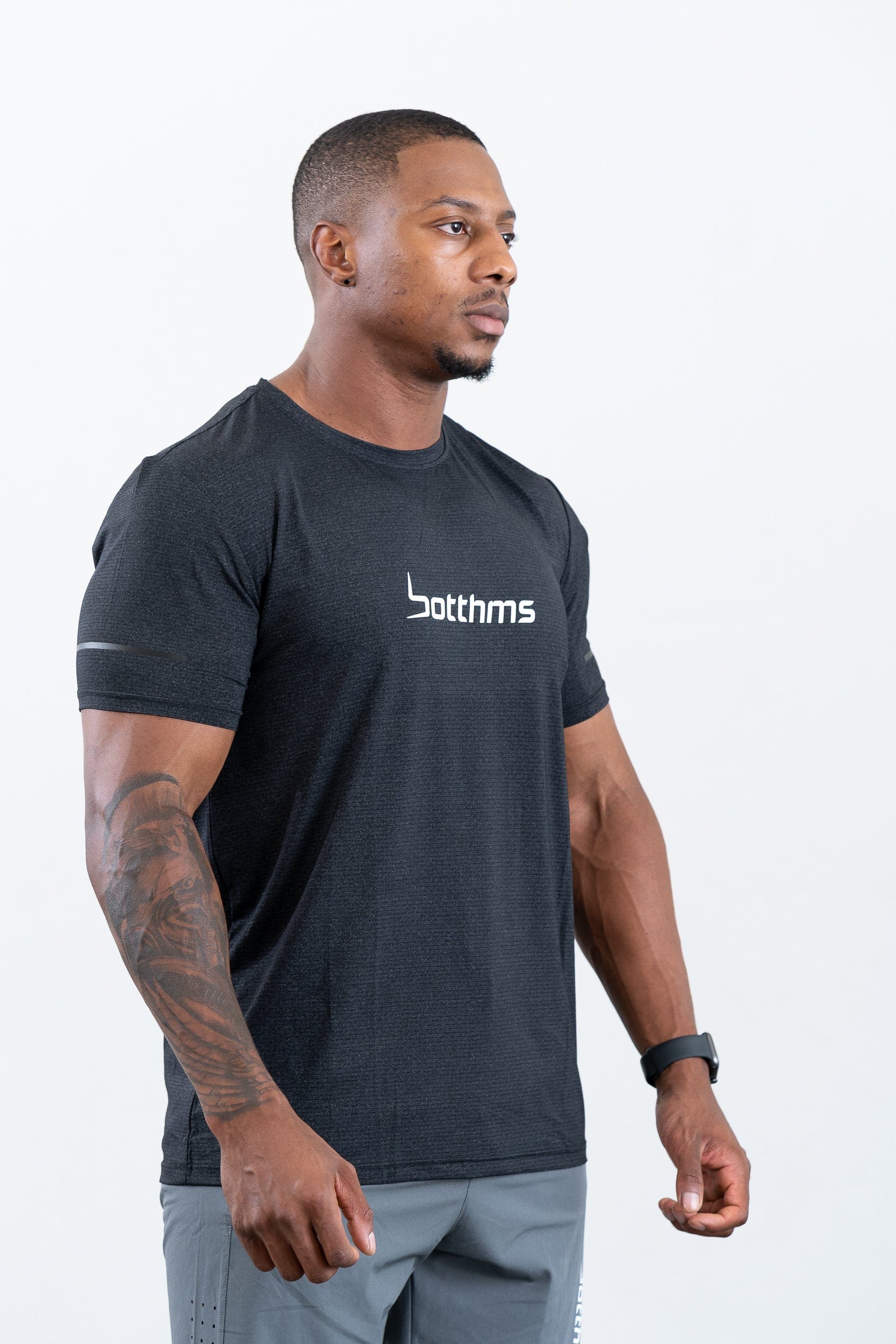 man standing wearing botthms black sport t-shirt- angled front-right view