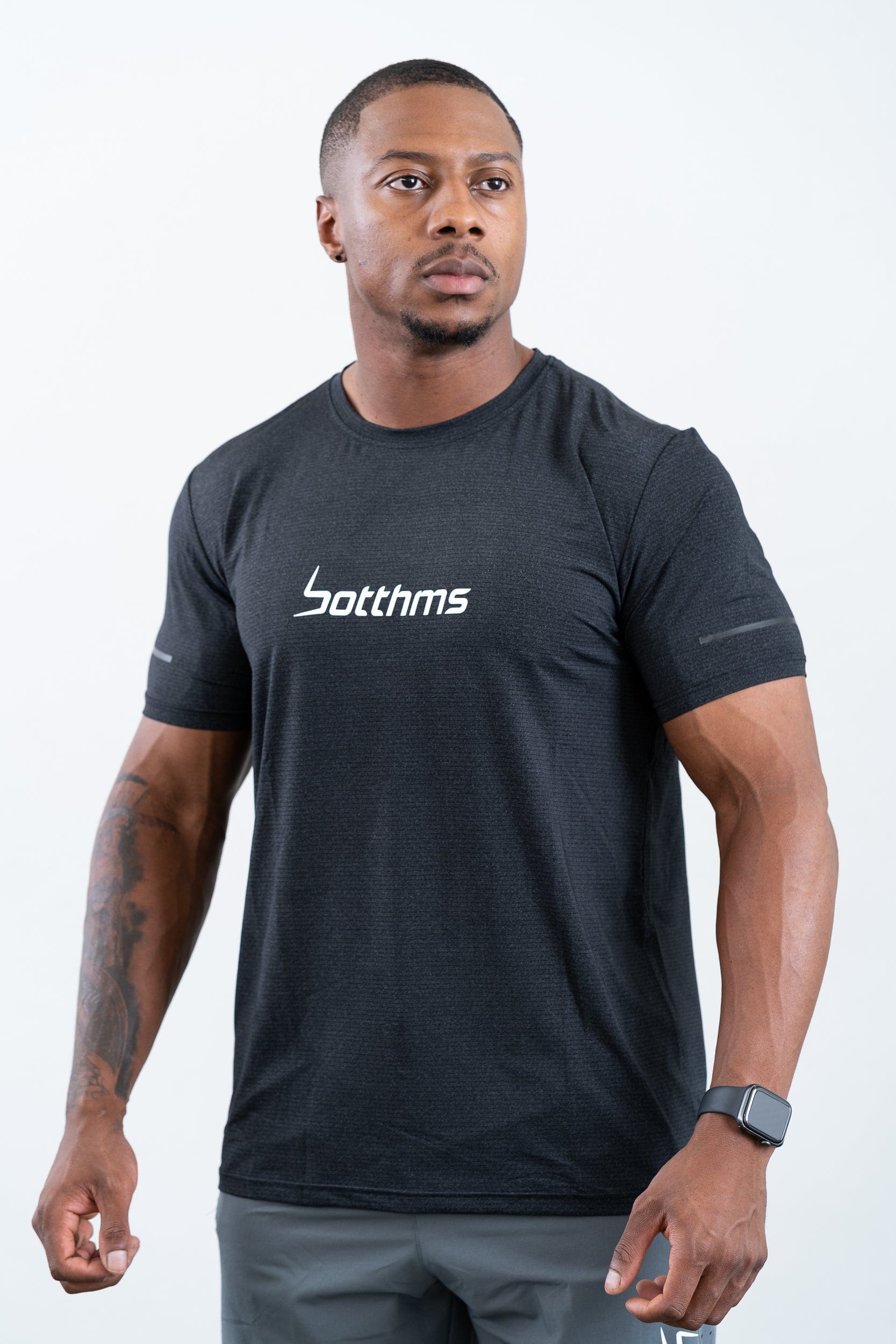 man standing wearing botthms black sport t-shirt- angled front view
