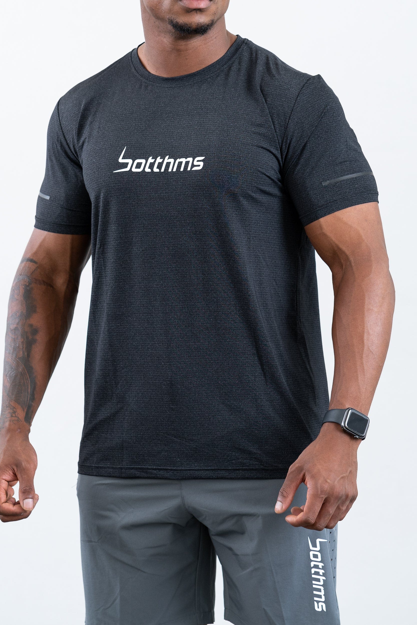 man standing wearing botthms black sport t-shirt- angled front view